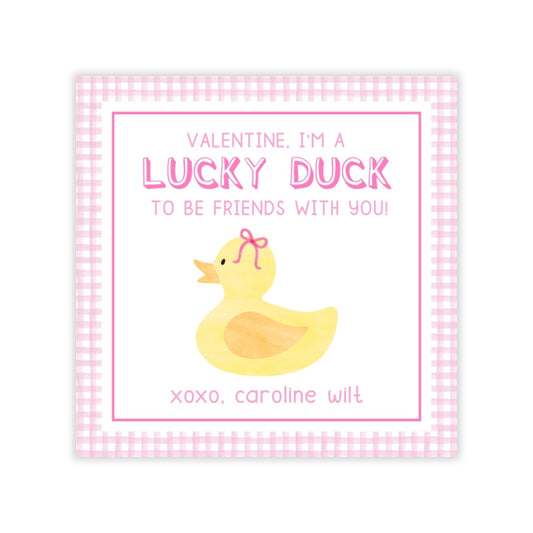 The image is a Valentine's Day card with a duck illustration. The card has a pink and white checkered border and a pink ribbon bow on the duck's head. The text on the card reads, "Valentine. I'm a LUCKY DUCK TO BE FRIENDS WITH YOU!" and "xoxo, Caroline Wilt".