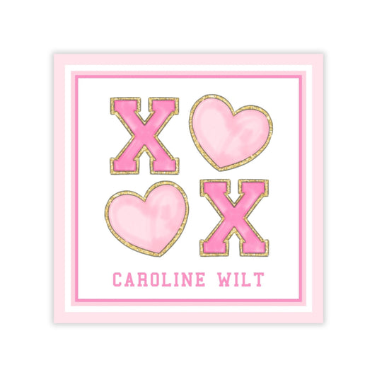 a pink and white design with the text "Caroline Wilt" and four heart-shaped letters "X" and "X" in the center.
