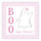 A personalized gift tag with 'BOO' and a ghost illustration, with the name 'Caroline' printed on it, set against a pink checkered background.