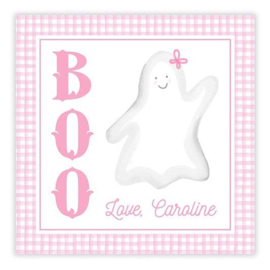 A personalized gift tag with 'BOO' and a ghost illustration, with the name 'Caroline' printed on it, set against a pink checkered background.
